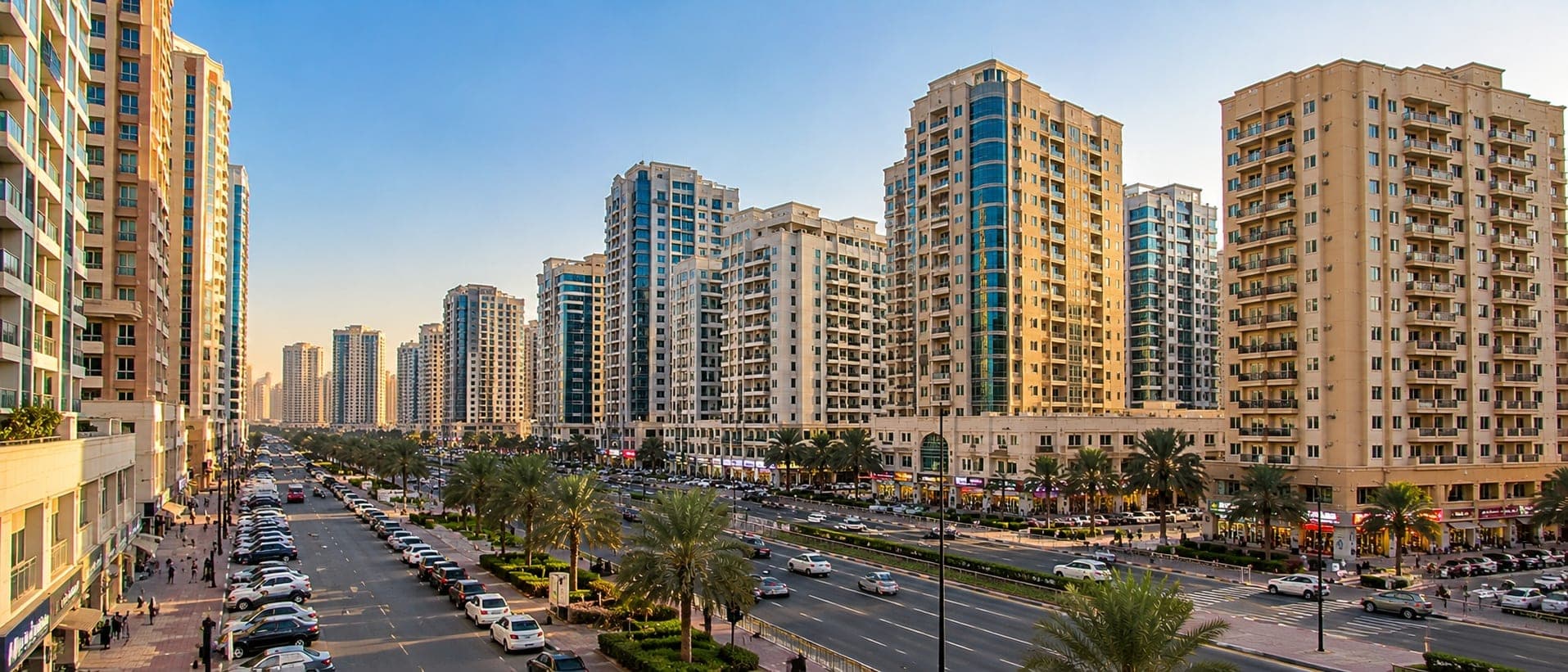 Al Nahda, Dubai — residential towers along a busy, palm-lined avenue